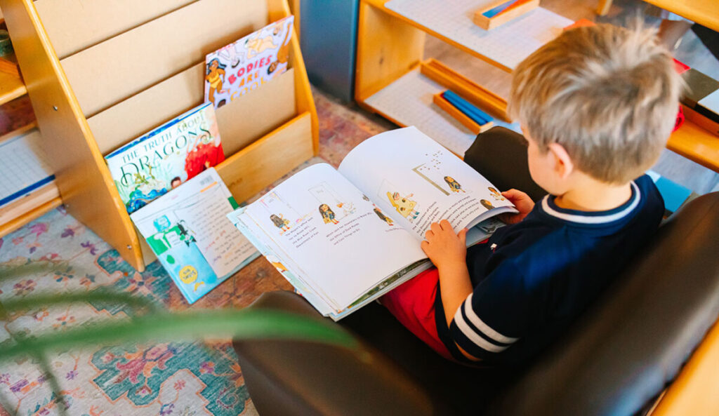 Montessori student reading a book