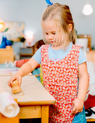 Little girl working at a table.